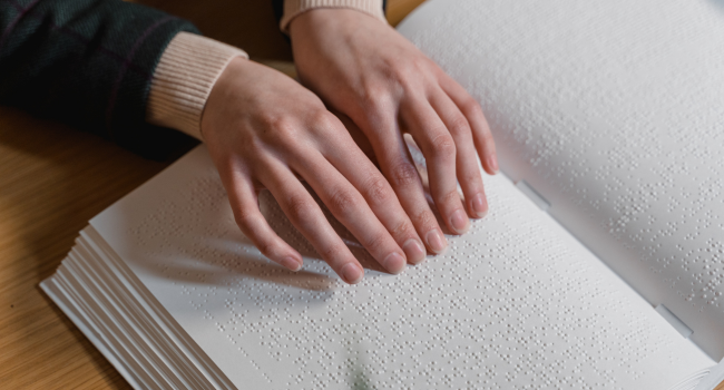 Les mains lisent un livre en braille.