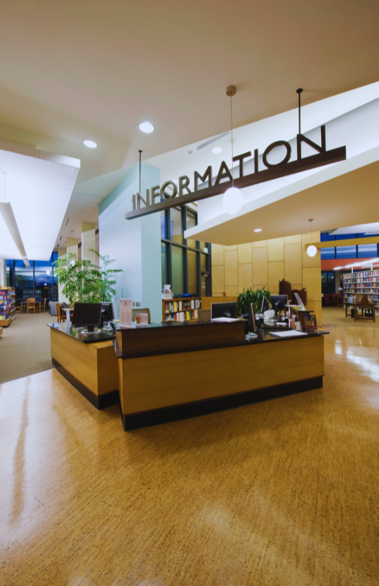 Desk in a library with a sign that says "Information" over it.