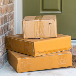 A stack of parcels sit in front of a door.