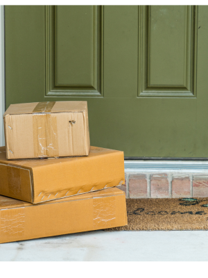 Packages are stacked in front of a greed door.
