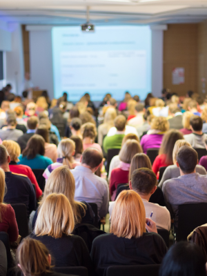 A crowd of people in a lecture hall gathered for a conference.