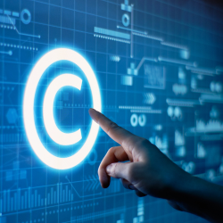 A hand points to the Copyright symbol on a large computer screen