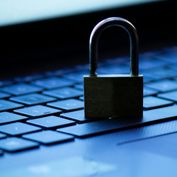 A padlock sits on a computer keyboard.