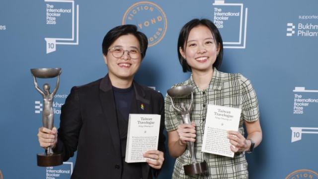 Photograph of the author of Taiwan Travelogue along with the translator holding up their award. 